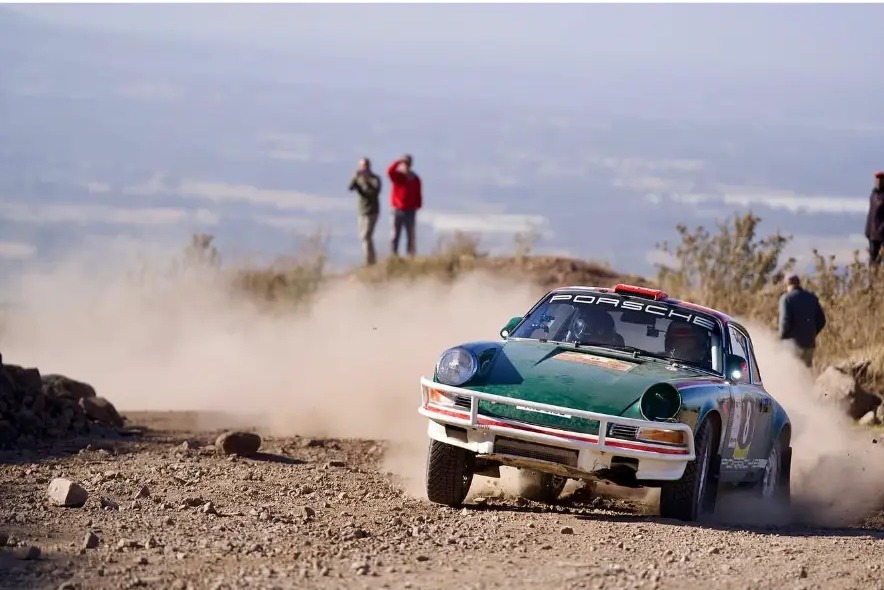 Vintage Porsche 911 sliding through dust at the East African Classic Safari Rally near Nanyuki, Kenya