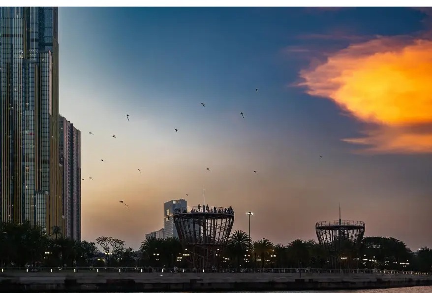 Kites flying over the river skyline at sunset in Ho Chi Minh City