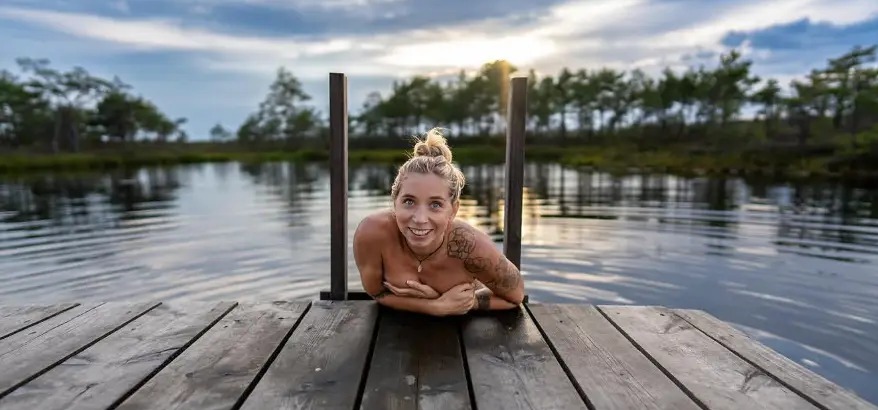 Swimmer resting on a wooden bog pier at Marimetsa raba, Estonia