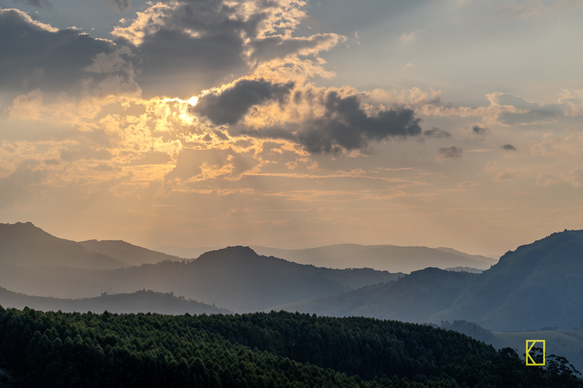 Misty forested mountain ridges beneath a glowing sunset sky at Mlilwane Wildlife Sanctuary, Eswatini