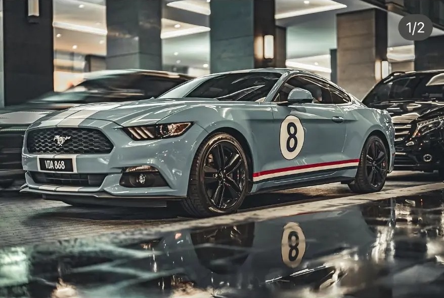 Vintage-liveried Mustang reflected on a wet parking deck