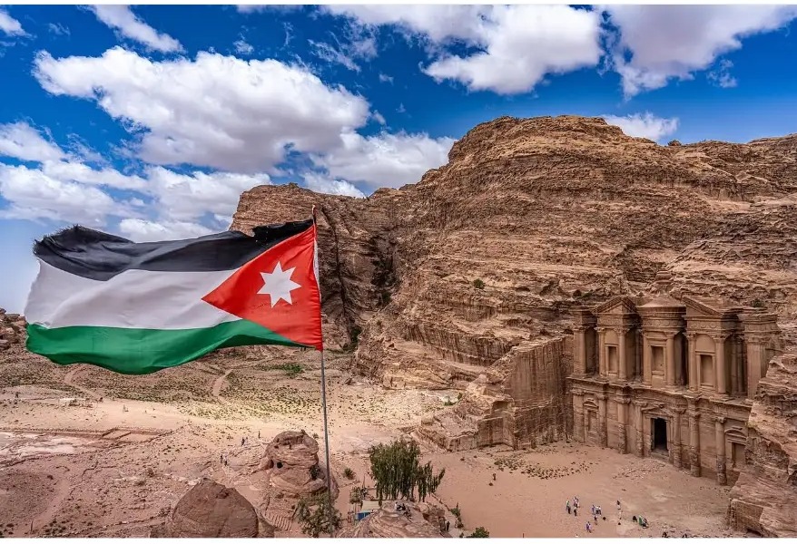 Jordanian flag flying above the Monastery carved into the rock at Petra, Jordan