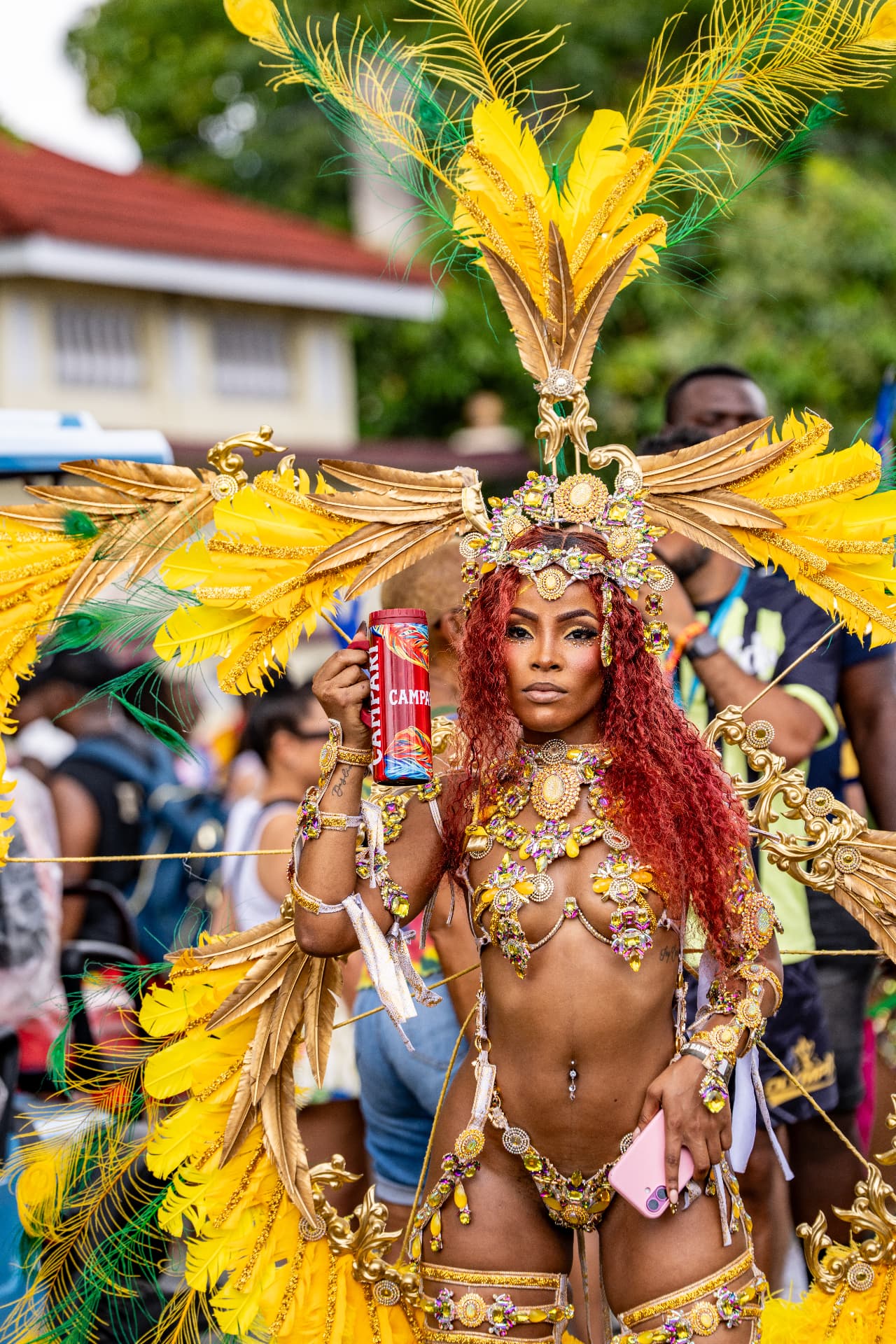 Carnival performer in a gold and yellow feathered, jewelled costume in Kingston, Jamaica