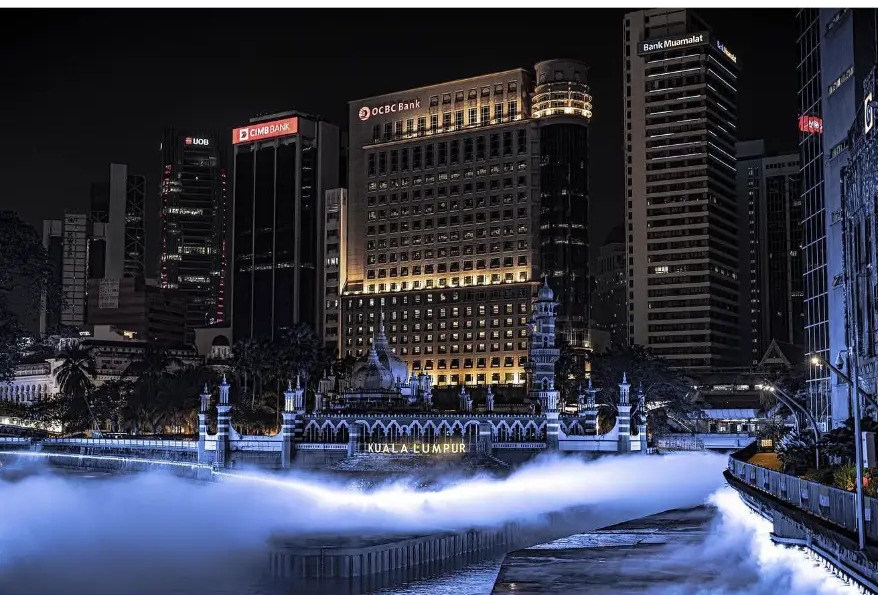 Masjid Jamek and the city skyline reflected in the misted River of Life
