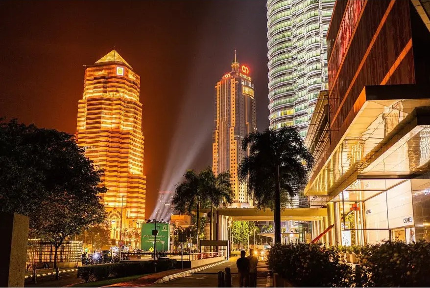 Golden tower lights and palms in the city centre at night