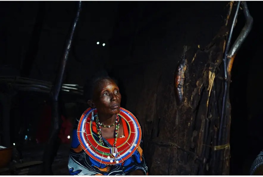 Masai woman in beaded jewellery sitting inside her home near Tsavo West National Park, Kenya
