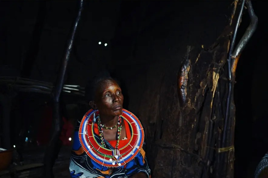 Masai woman in beaded jewellery sitting inside her home near Tsavo West National Park, Kenya