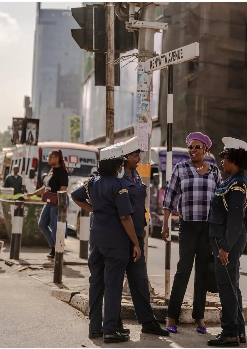 Traffic officers talking with a woman on the corner of Kenyatta Avenue in Nairobi, Kenya