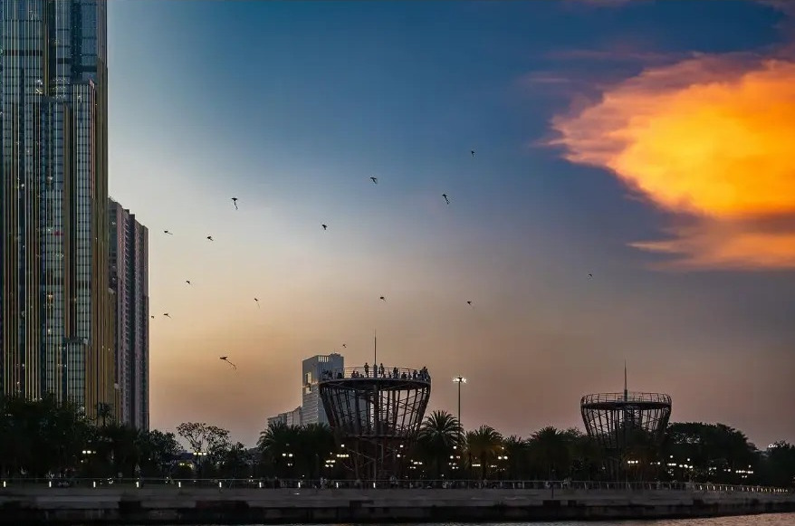 Kites flying over the river skyline at sunset in Ho Chi Minh City