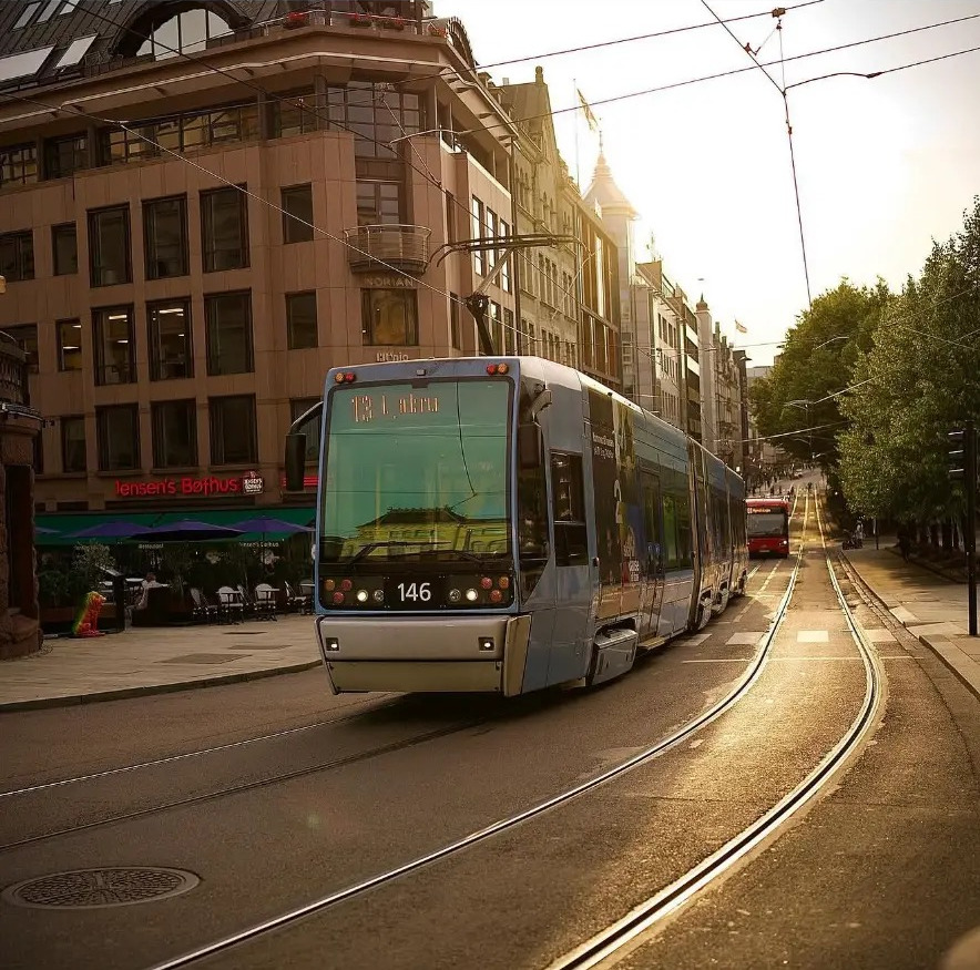 Tram curving along wet tracks in golden evening light