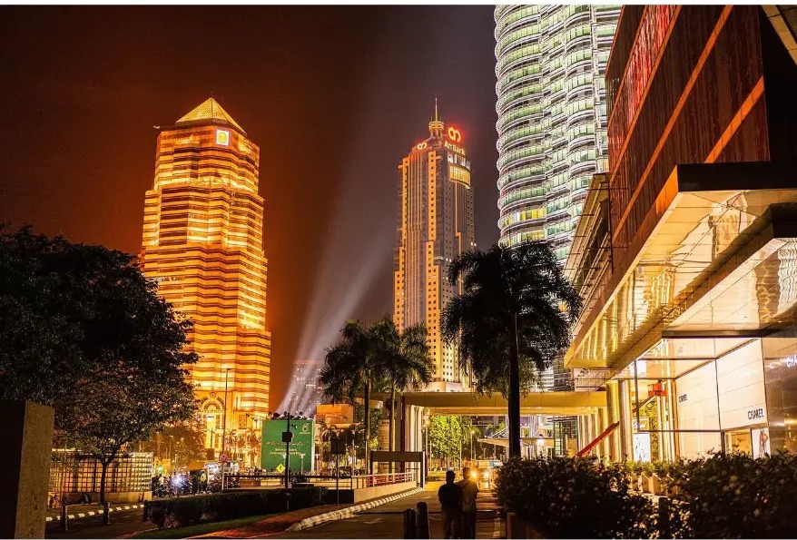 Golden tower lights and palms in the city centre at night