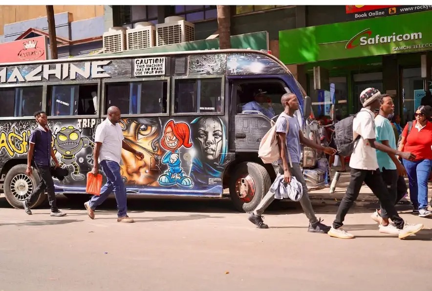 Graffiti-covered matatu bus and pedestrians on Tom Mboya Street, Nairobi, Kenya